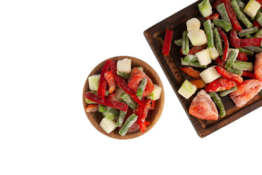 Fresh Frozen vegetables, tomatoes, string beans, zucchini, red pepper on wooden cutting board and wooden bowl, top view. White background, design element, copy space
