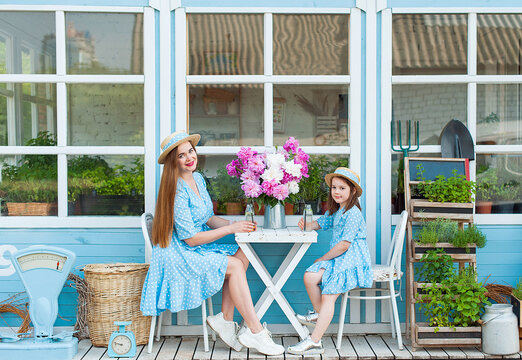 Mother And Daughter Drinking Cocktail In Cafe Outside