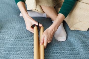 woman cuts with scissors paper for wrapping Christmas presents