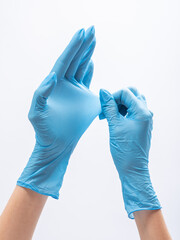 Isolated hands in blue medical gloves. Stretching of durable nitrile gloves on white background