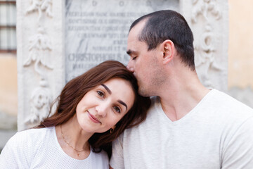 Obraz premium Man and woman romantically kissing on the city street in summer