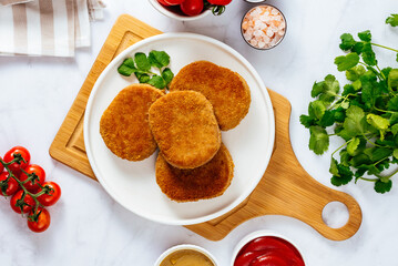 deep fried chicken cutlets on a plate with sauce