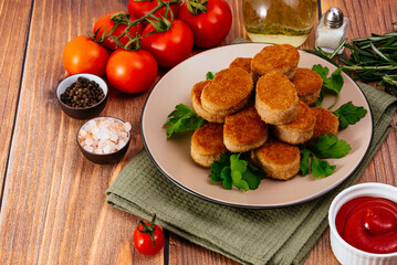 Fototapeta na wymiar chicken nuggets on a plate with sauce, wooden countertop