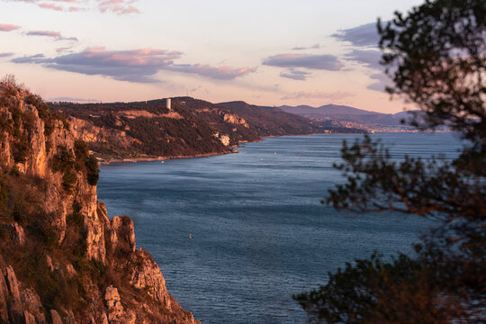 Golden sunset at the sea with rocky coastline, view to Trieste gulf