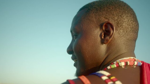 Side View Of An African Masai Warrior Looking Over The Horizon In Kenya During Daytime. Close up