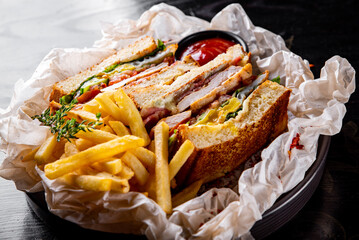 Club sandwich with French fries and sauce