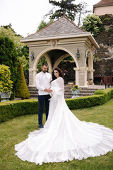 Obraz premium Elegant pregnant woman in luxury white dress walking aroung with her handsome husband