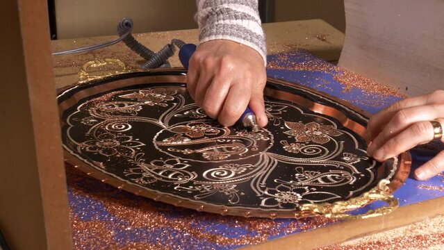 Handicrafts. Traditional motifs embroidered on copper with various tools, copper ornament art. Engraving eye-catching patterns on copper.