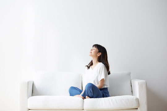 ソファの上で深呼吸する女性