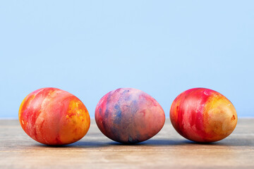 Colorful Easter eggs on a wooden background with a place for text. Happy Easter concept.