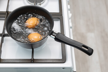 chicken egg with broken shell in boiling water