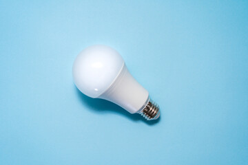 Energy saving light bulb on blue background. Savings