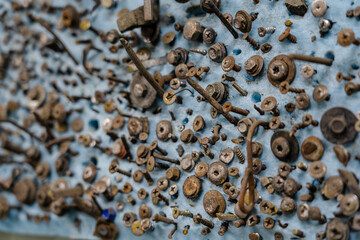 A lot of old nails and self-tapping screws driven into a board
