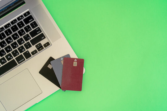 Several credit cards on laptop keyboard with green background