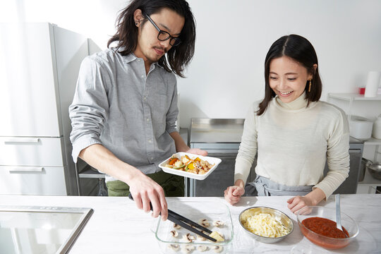 キッチンで料理をする男女