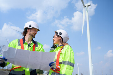 Man and female engineer stationed at the Natural Energy Wind Turbine site. with daily audit tasks...
