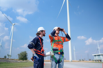 Surveyor and engineer Examine the efficiency of gigantic wind turbines that transform wind energy into electrical energy that is then used in daily life.