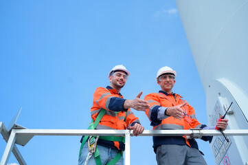 Surveyor and engineer Examine the efficiency of gigantic wind turbines that transform wind energy into electrical energy that is then used in daily life.