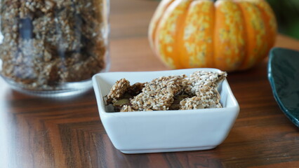 Seed crackers in a square bowl on a wooden table.