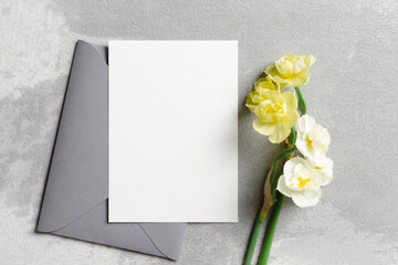 Paper invitation card mockup with envelope and daffodils flowers