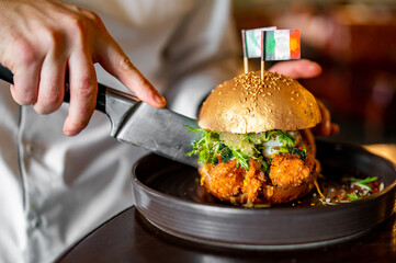chef cut Delicious seafood burger with shrimps, crab, caviar, cheese and vegetables