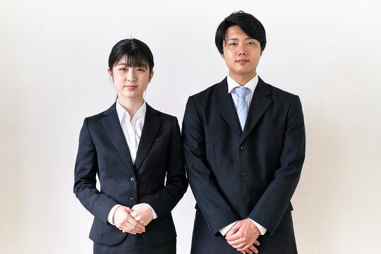 前に手を組む男女の就活生