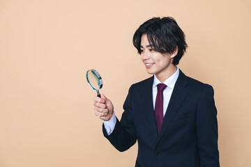 虫メガネで観察する若い男性