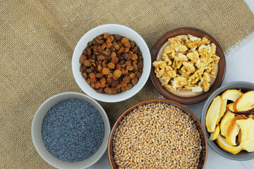 Wheat, raisins, poppy seeds, walnuts, dried apples. Ukrainian kutia ingredients in bowls.