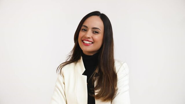 Successful young businesswoman in formal wear smiling against a white background. High quality 4k footage