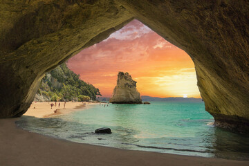 Sunset seen through a natural arch with island and turquoise water