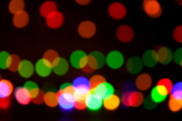 Round, bright, blurry garland lights. Abstract illustration of colorful bokeh lights on a dark background.