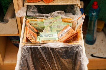 Banknotes of 50 and 100 euros lie in the trash can.