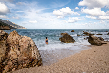 Une femme se baigne dans la Méditerranée dans une paysage grandiose