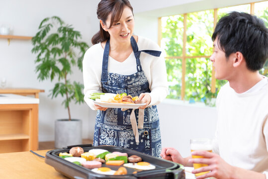 生ビールで焼肉を食べる３０代夫婦