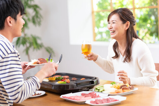 生ビールで焼肉を食べる３０代夫婦