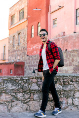 Mexican student in Guanajuato city, exploring a colorful village with a checked shirt. 