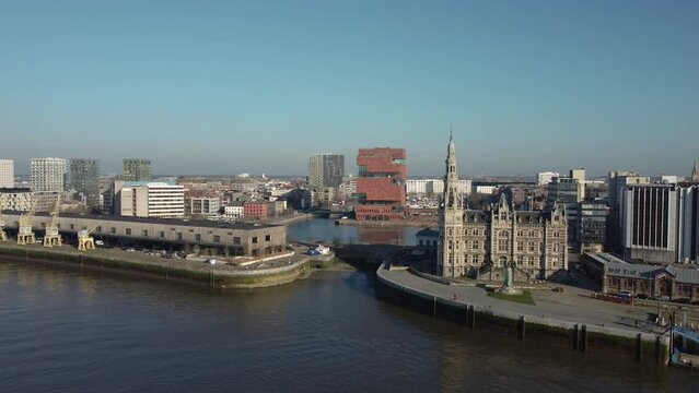 Cinematic Establishing 4k drone shot of the loodsgebouw (the Antwerp pilot building) in the Belgian city of Antwerpen and the MAS museum in the backgound over the river Scheldt (Schelde)