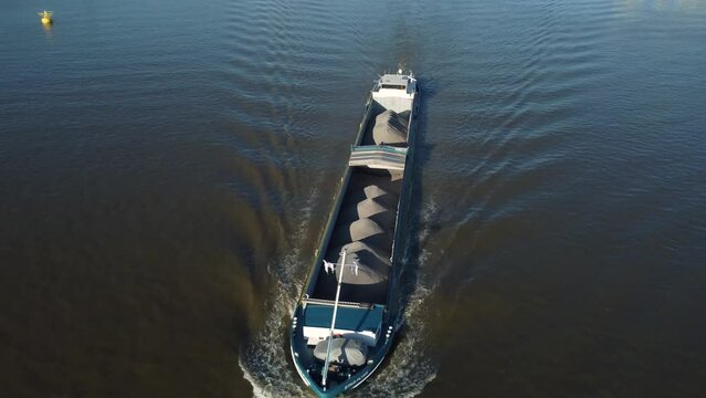 Barge loaded with sand on the River Scheldt in Antwerp seen from above by drone