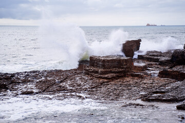 Sea waves and rock stones on the beach.