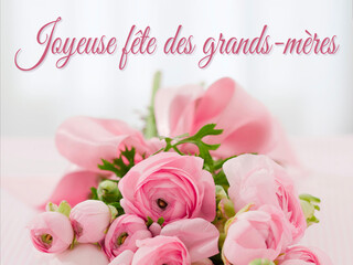 carte ou bandeau pour souhaiter une joyeuse fête des grands-mères en rose sur un fond gris en effet bokeh et en dessous  un bouquet de fleurs rose 