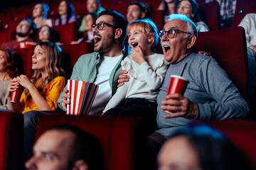 Grandfather, son and granddaughter in movie theater. - obrazy, fototapety, plakaty