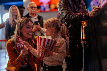 Joyful mother and daughter at movies.