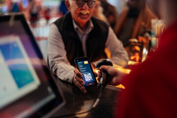 Cashier scanning qr code on mobile app.