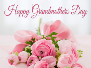card or banner to wish a happy grandmother's day in pink on a gray background in bokeh effect and below a bouquet of pink flowers
