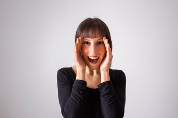 Portrait of a girl on white background. Brown short hair girl. Happy girl with her hands on her face as if she wants to hide	