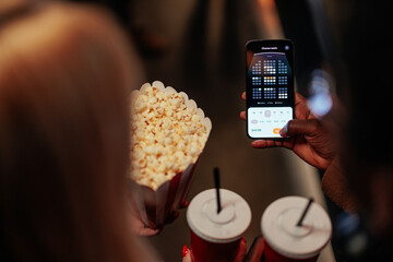 People booking movie theater seats with mobile app.