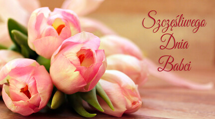 kartka lub baner, aby życzyć szczęśliwego dnia babci w kolorze różowym na beżowym tle z efektem bokeh i obok bukietu różowych kwiatów tulipanów - obrazy, fototapety, plakaty