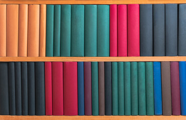 bookcase with books with different colored spines