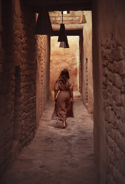 A little Girl walks within the alleys of the restored Alula's old town, 900 years old historical village in Medina, Saudi Arabia. 