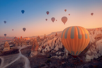 Sunrise with hot air balloons fly over deep canyons, valleys Cappadocia Goreme National Park Turkey, Travel tourist concept